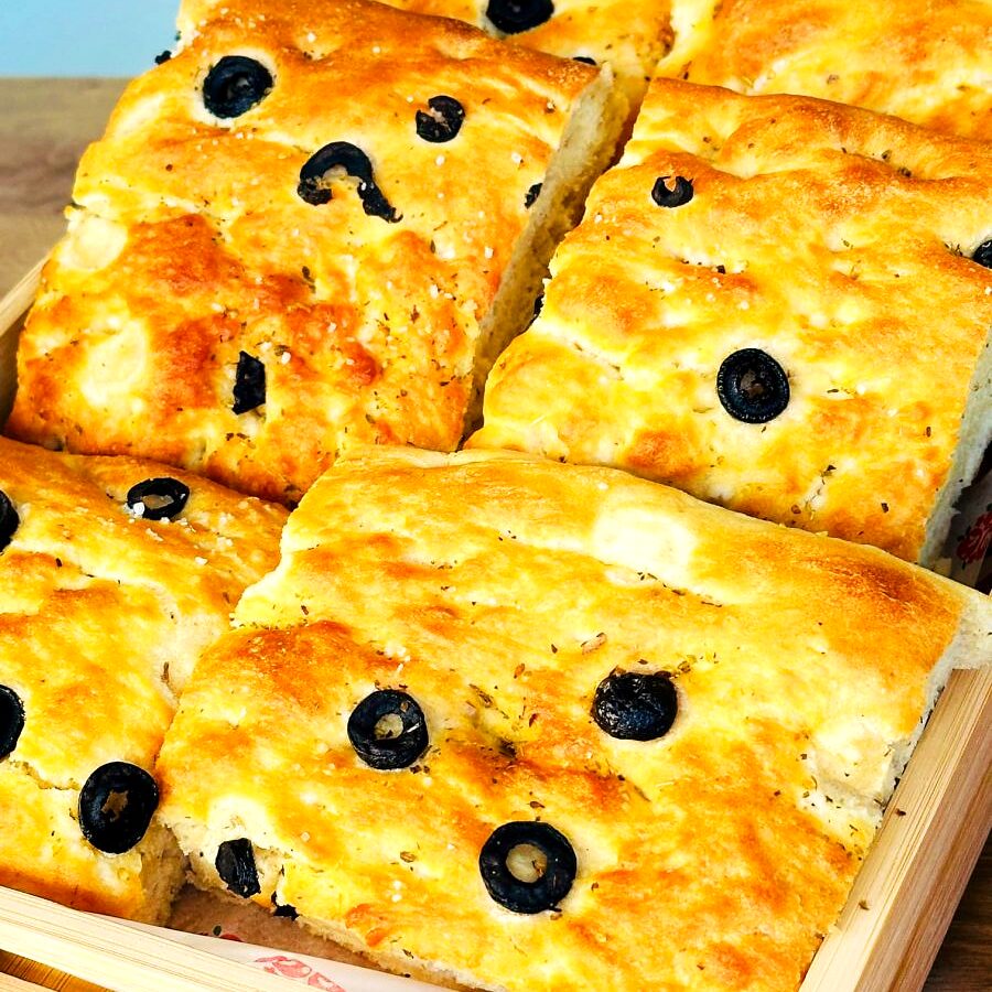 Focaccia cu măsline, tăiată în bucăți pe tavă
