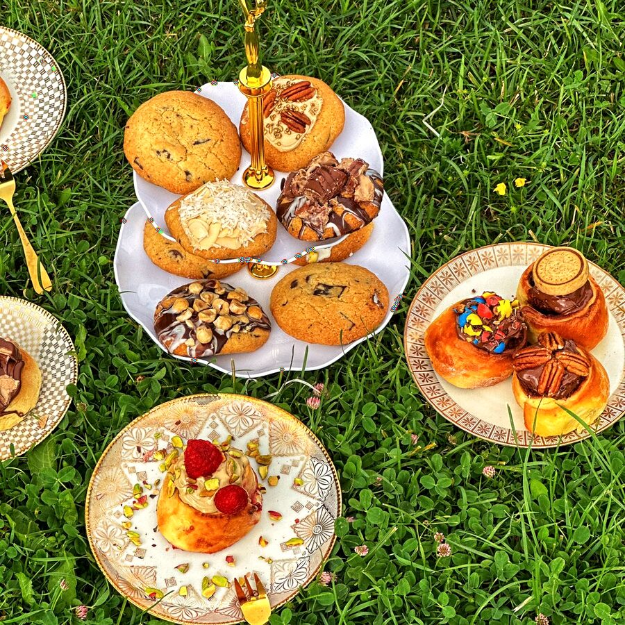 Platouri cu fursecuri și prăjituri așezate pe iarbă, la un picnic